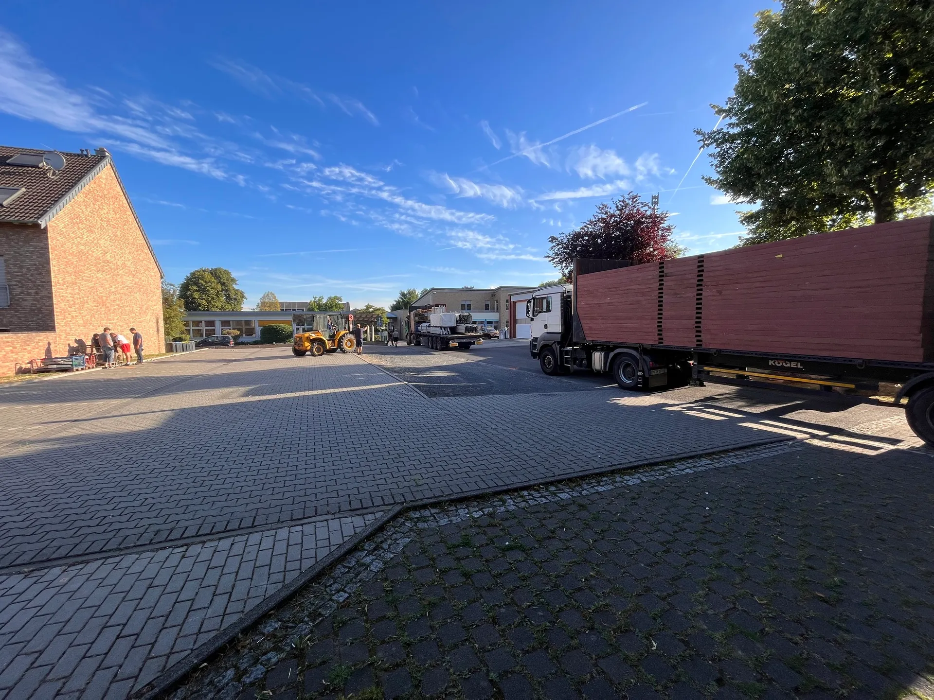 Anlieferung von Festzelt-Material per LKW und Anhänger auf dem Festplatz, Gabelstapler im Hintergrund