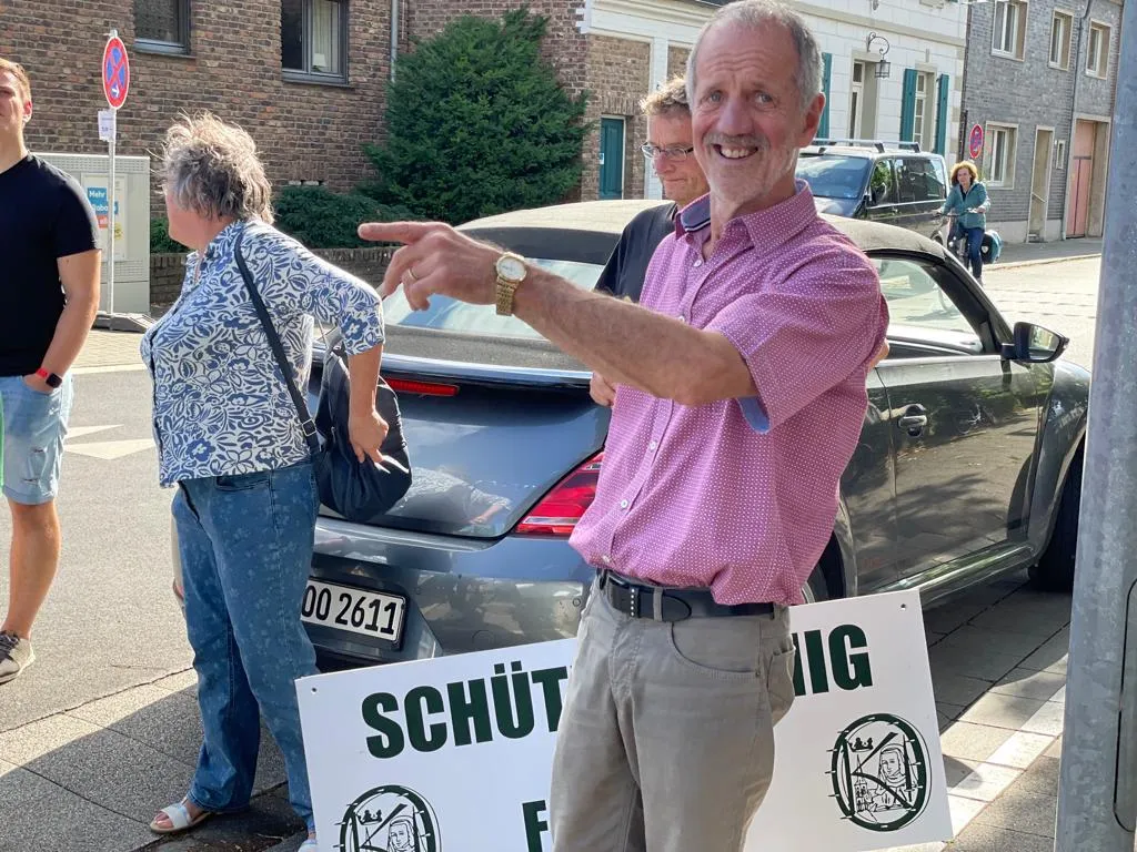 Lachender Schützenbruder zeigt nach oben, neben ihm ein „SCHÜTZENKÖNIG"-Schild