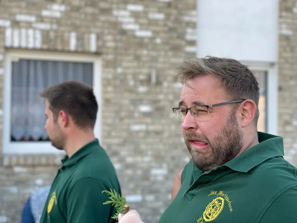 Schützenschwester im Vereins-Polo bindet Tannenzweige zusammen