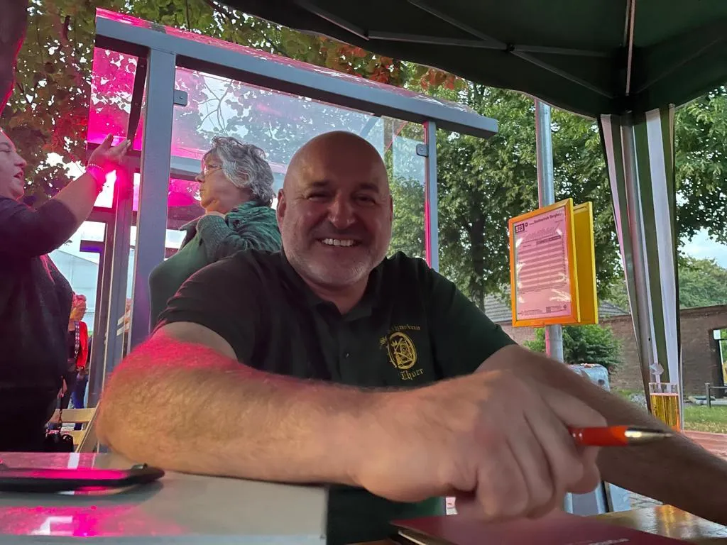 Lachender Schützenbruder am Tisch unter dem Pavillon der Sommernacht 2023