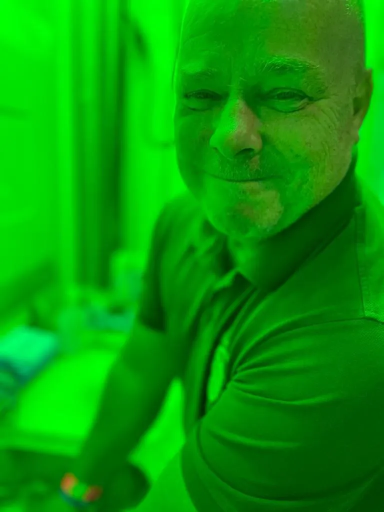 Porträt eines lachenden Schützenbruders im grünen Bühnenlicht der Sommernacht