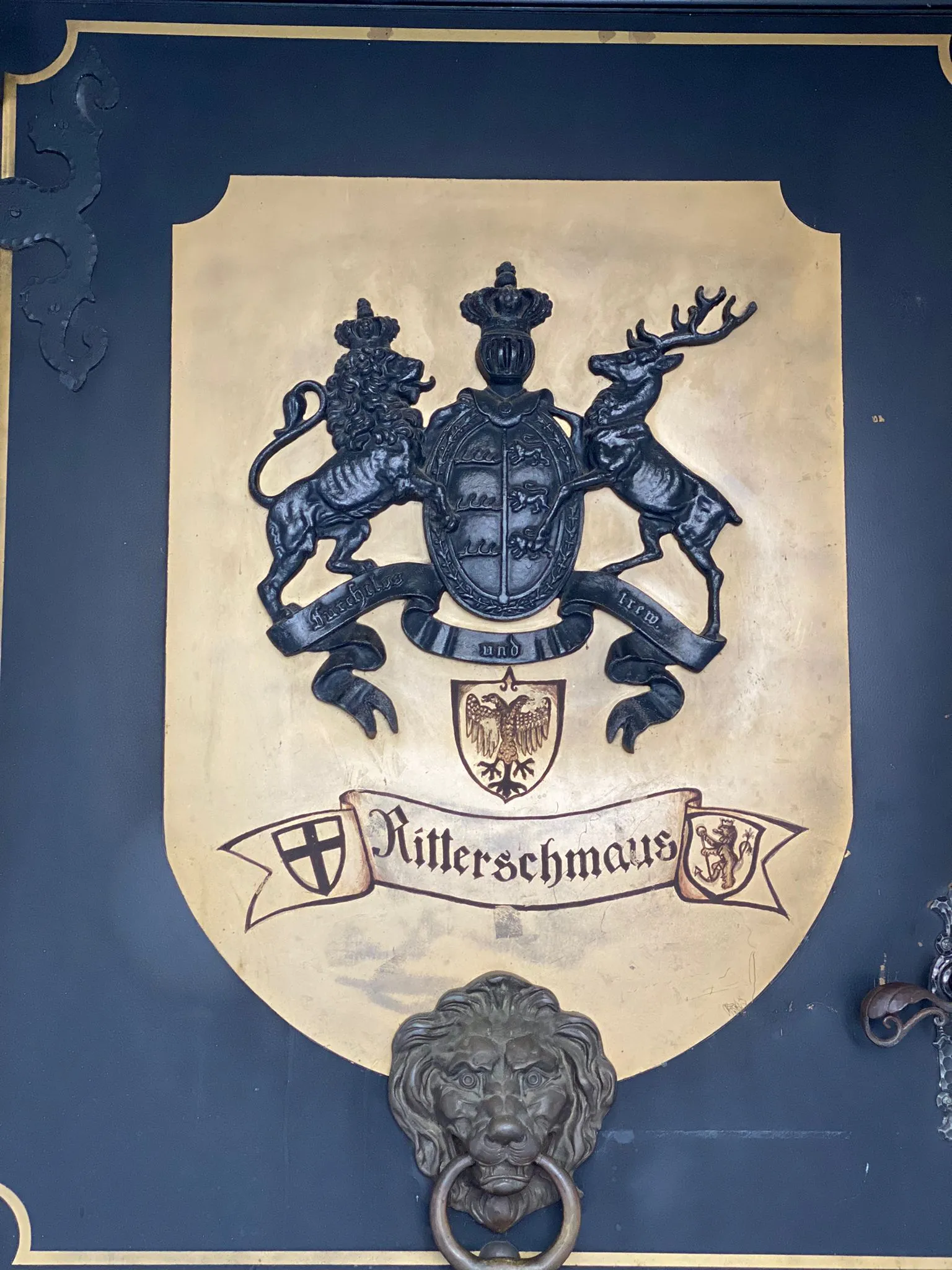Wappenschild des Restaurants „Ritterschmaus" mit Löwen, Hirsch und Türkopf-Klopfer