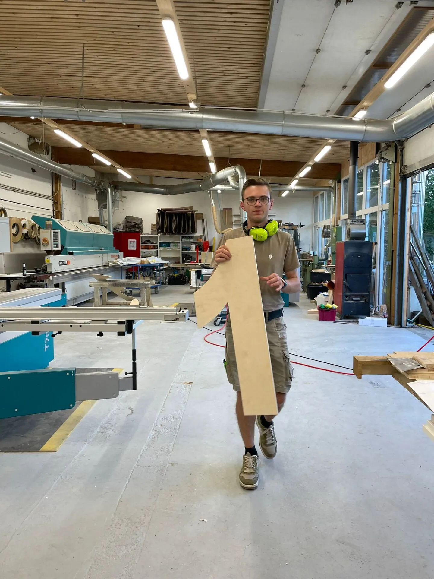 Junges Vereinsmitglied trägt eine gefräste Holz-„1" durch die Tischlerei – Eigenbau der „1634"-Buchstaben für die Sommernacht-Deko