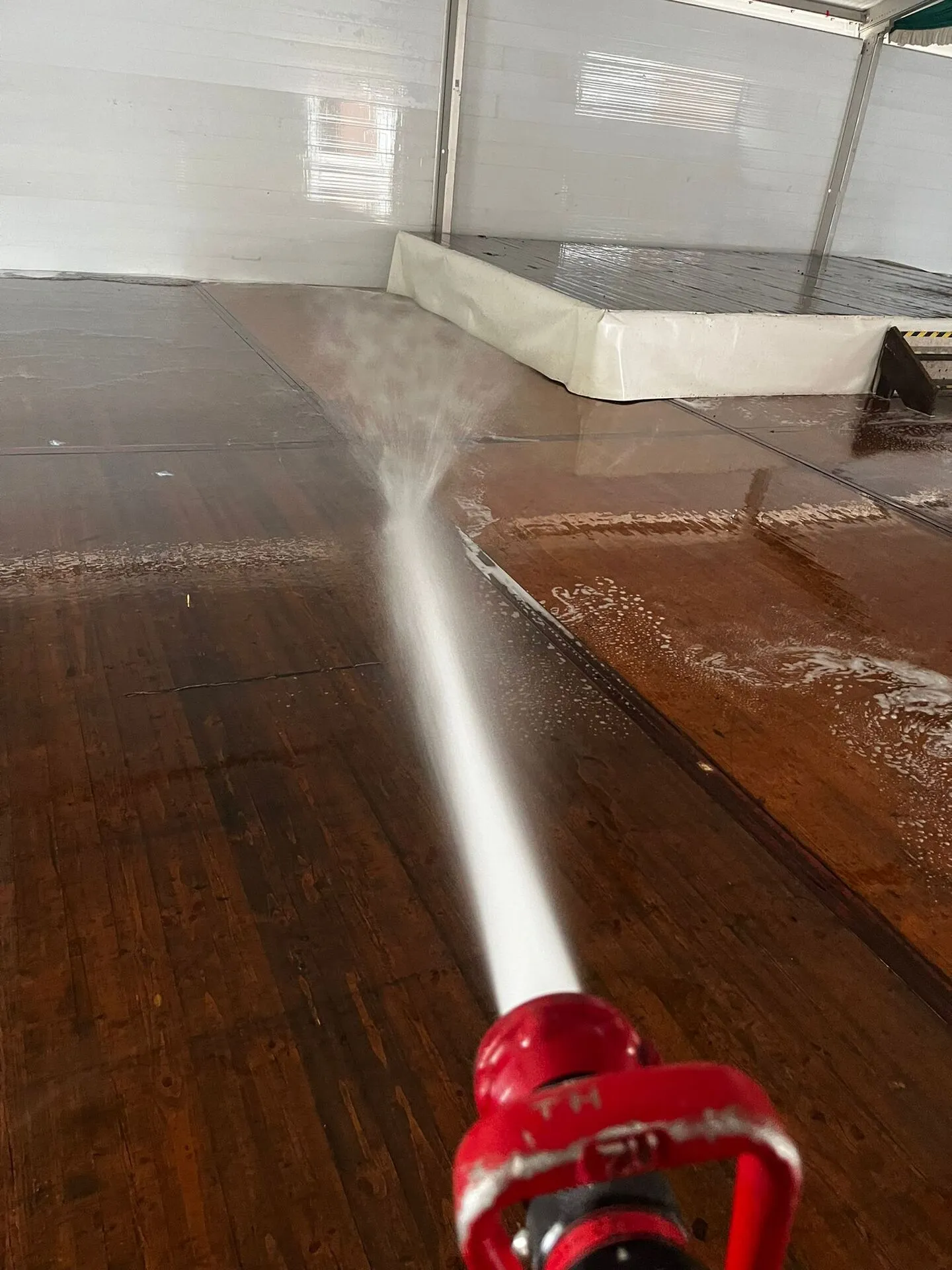 Reinigung des Festzeltbodens mit dem Wasserschlauch