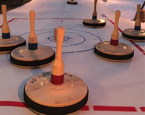 Eisstöcke mit roten und blauen Griffen auf einer Spielfläche